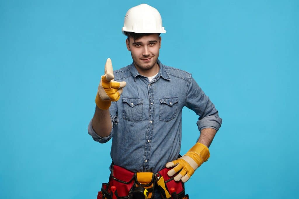 Confident handyman pointing
